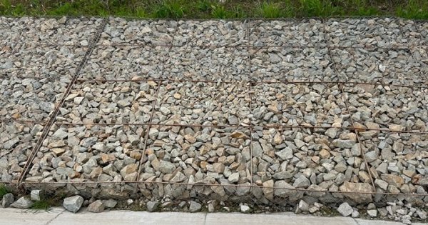 Ce mai fură românii: plasa de sârmă care susține pietrele de pe un drum...