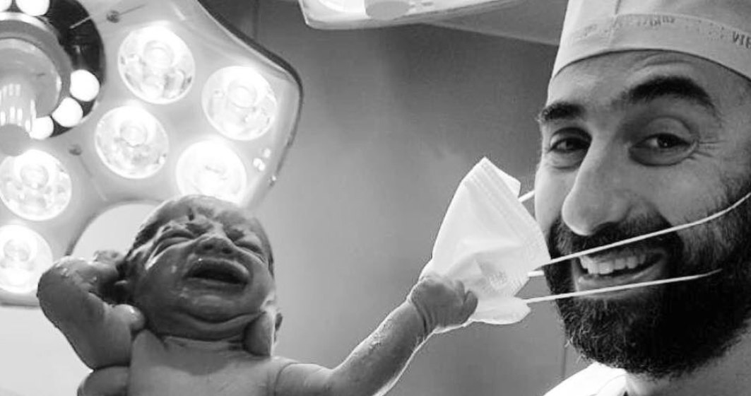 Imagine devenită virală: un nou-născut încearcă să smulgă masca doctorului