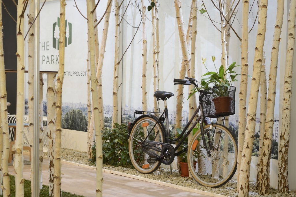 Standul The Park de la targul imobiliar Project Expo: copaci si biciclete pentru a promova apartamente langa parc