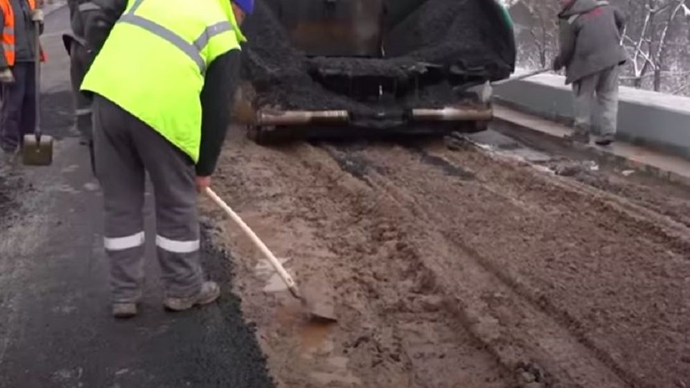 Drum național asfaltat peste noroi. Drumar: „Turnăm niște asfalt ca să fie”