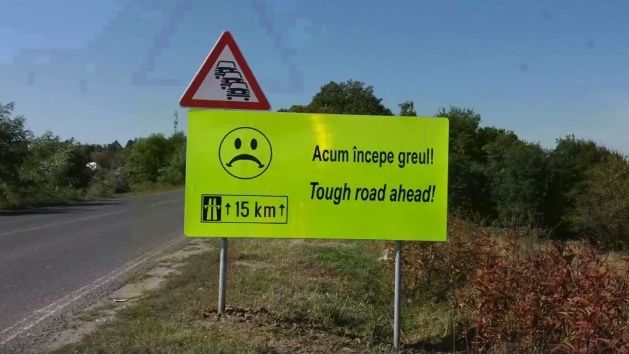 Indicatoare cu texte ca "Acum incepe greul" si "Rezista", montate de drumarii din Timisoara pe un sector de drum greu de parcurs