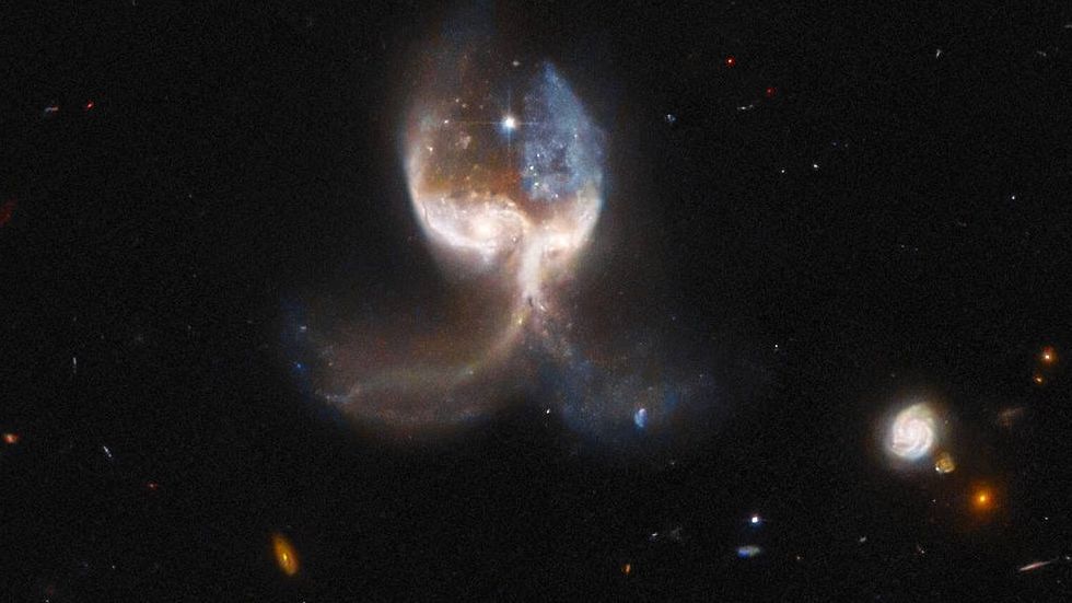 Măcar în cer, dacă nu pe pământ: telescopul spațial Hubble a dezvăluit două galaxii în proces de fuziune, numite Aripa de înger