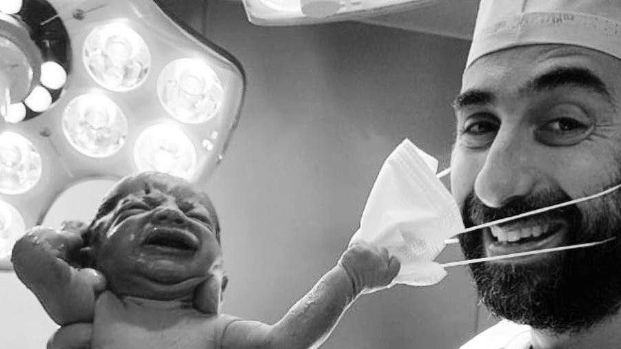 Imagine devenită virală: un nou-născut încearcă să smulgă masca doctorului